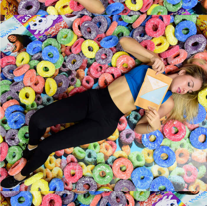 Chica recostada sobre cereal sosteniendo producto freya